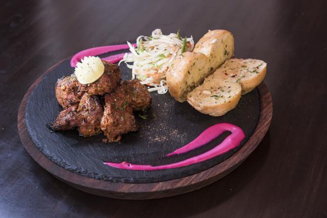 The tikka botis are served with soft ladi paos and a raw papaya salad. The botis are not the chewy street fare but generously marinated strips that pull apart effortlessly; the salad, however, is inadequately tart. (Aalok Soni/HT photo)
