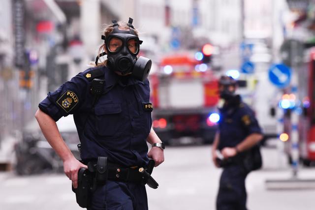 Police officers work at the scene where a truck crashed into the Ahlens department store at Drottninggatan in central Stockholm. (AFP Photo)