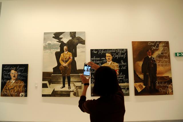 A visitor takes photo of the art work "The Greek way", an installation by Piotr Uklanski and McDermott & McGough, based on film stills of Leni Riefenstahl. (Reuters) A visitor takes photo of the art work "The Greek way", an installation by Piotr Uklanski and McDermott & McGough, based on film stills of Leni Riefenstahl. (Reuters)