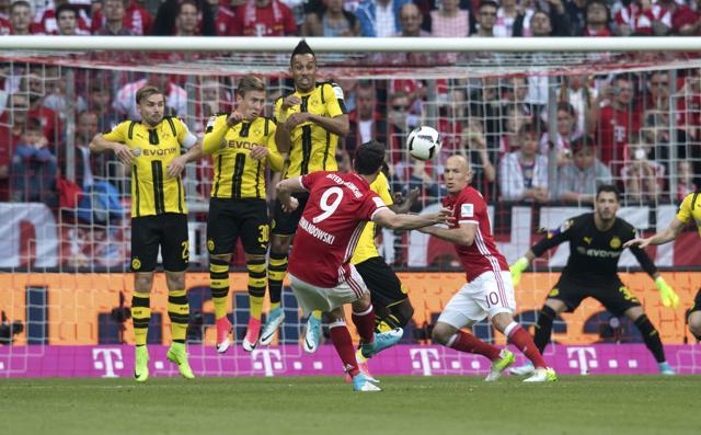 Munich's Robert Lewandowski, front, scores from a free-kick against Borussia Dortmund. (AP) Munich's Robert Lewandowski, front, scores from a free-kick against Borussia Dortmund. (AP)