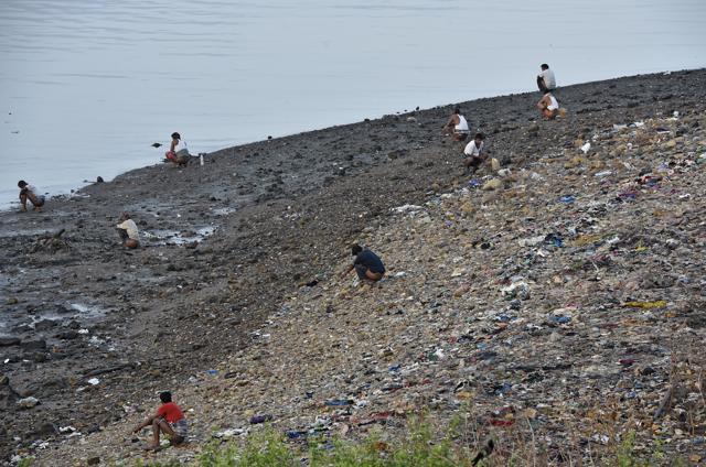 Men squat at Bandra Reclamation early in the morning. Women from the nearby settlements go in groups early in the morning or hold back until after sundown. (Vijayanand Gupta/HT Photo) Men squat at Bandra Reclamation early in the morning. Women from the nearby settlements go in groups early in the morning or hold back until after sundown. (Vijayanand Gupta/HT Photo)