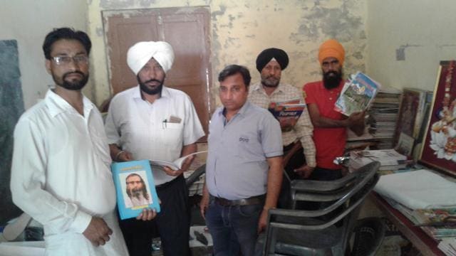 Deputy DEOs Ramjit Singh (second from left) and Jagroop Singh (fourth from left) with literature they seized from a school that remained open on Ambedkar Jayanti, in Dulowal village of Mansa district on Friday. (HT Photo)