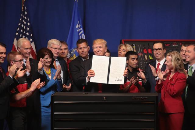 President Donald Trump signs an executive order to try to bring jobs back to American workers and revamp the H-1B visa guest worker program during a visit to the headquarters of tool manufacturer Snap-On on April 18, 2017. (AFP Photo) President Donald Trump signs an executive order to try to bring jobs back to American workers and revamp the H-1B visa guest worker program during a visit to the headquarters of tool manufacturer Snap-On on April 18, 2017. (AFP Photo)