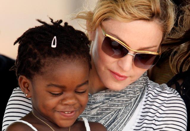 Pop star Madonna sits with her adopted Malawian child Mercy James during a bricklaying ceremony at the site of her Raising Malawi Girls Academy. (REUTERS) Pop star Madonna sits with her adopted Malawian child Mercy James during a bricklaying ceremony at the site of her Raising Malawi Girls Academy. (REUTERS)