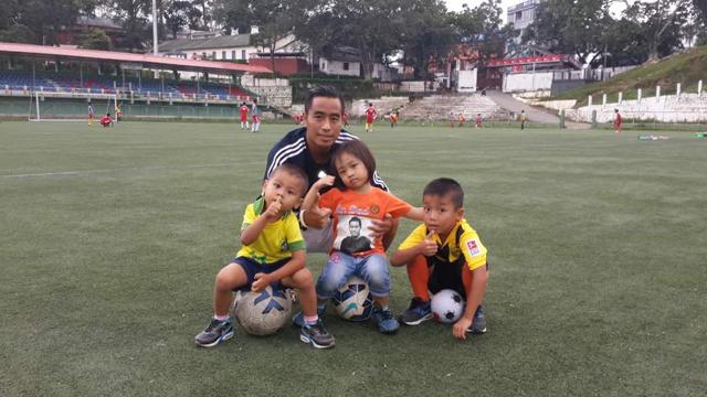 Shylo Malsawmtluanga with his daughter and two young fans. The spectators’ gallery of the Assam Rifles ground behind them is named after him. (HT Photo) Shylo Malsawmtluanga with his daughter and two young fans. The spectators’ gallery of the Assam Rifles ground behind them is named after him. (HT Photo)