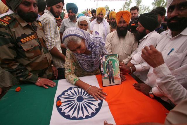 A relative touches the coffin of naib subedar Paramjit Singh in the village of Vein Poin on the outskirts of Amritsar on Tuesday. (Reuters Photo) A relative touches the coffin of naib subedar Paramjit Singh in the village of Vein Poin on the outskirts of Amritsar on Tuesday. (Reuters Photo)