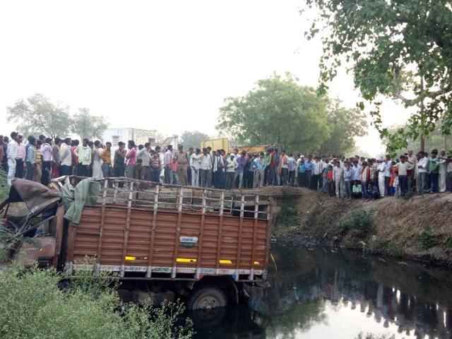 People crowd the accident site where a truck had gone off road. The vehicle was carrying a wedding party of about 50 people from Jalesar. (HT Photo)