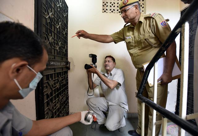 Delhi police photographer Sanjeev Kumar Singh capturing the door through which a burglar has broken in. (Raj K Raj/HT Photo) Delhi police photographer Sanjeev Kumar Singh capturing the door through which a burglar has broken in. (Raj K Raj/HT Photo)