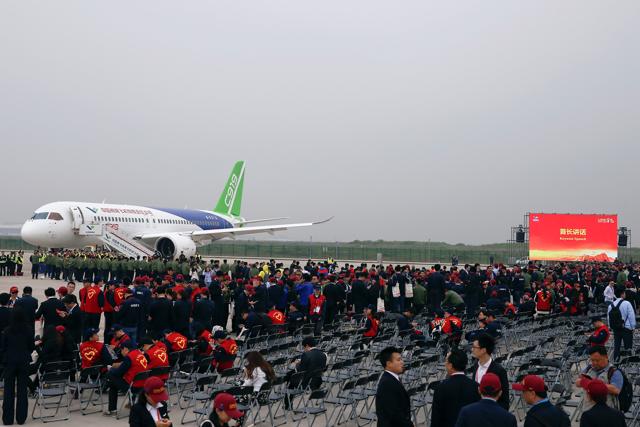 People gather around China's home-grown C919 passenger jet following its maiden flight at the Pudong International Airport in Shanghai. (REUTERS) People gather around China's home-grown C919 passenger jet following its maiden flight at the Pudong International Airport in Shanghai. (REUTERS)