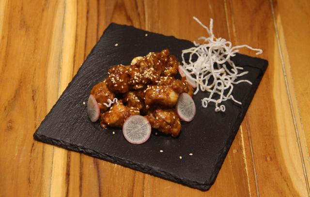The mysteriously named Chicken Kim Jong-Un was good - a platter of nuggets coated in a sticky-hot-tart glaze. (Bhushan Koyande / HT Photo)