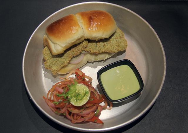 The Machhi Pao is fish buried so deep in bread and rawa batter, that you taste the lachha onions and chutney more than you do the sea bass. (Bhushan Koyande / HT Photo)
