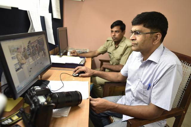 Vijay Raj, a police photographer with Meerut Police working on his pictures on the computer. (Burhaan Kinu / HT Photo)