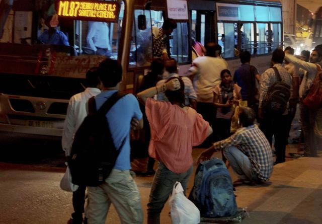 Commuters at the Munirka bus-stop in New Delhi on Saturday. (PTI Photo)