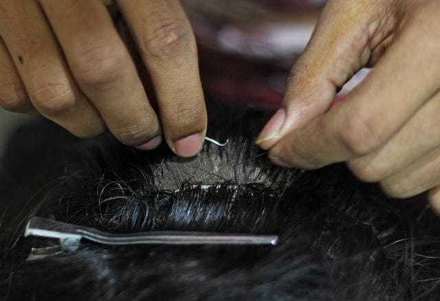 This is the knotting stage, where the real skill comes in. Two or three strands of hair are knotted into the net at a time. “This needs total concentration and a keen eye for detail,” says Bhupatkar. It’s almost like fine carpet-making. If the hair is not knotted delicately and exactly, the hair won’t fall right. (Satyabrata Tripathy / HT Photo)