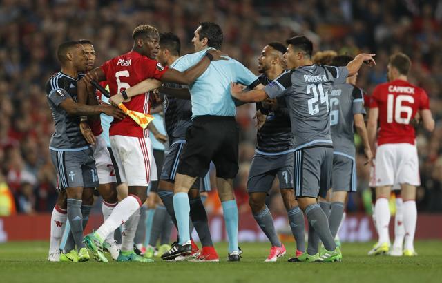 Manchester United's Paul Pogba clashes with Celta Vigo's Facundo Roncaglia as referee Ovidiu Hategan intervenes. (REUTERS)