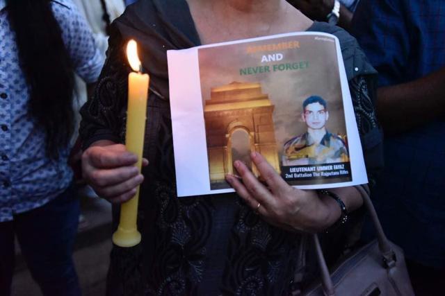 A women marcher holding a candle and a poster of Ummer Fayaz. (Burhaan Kinu/HT Photo) A women marcher holding a candle and a poster of Ummer Fayaz. (Burhaan Kinu/HT Photo)
