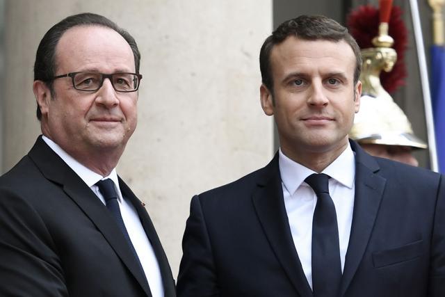 French newly elected President Emmanuel Macron (R) is welcomed by his predecessor Francois Hollande as he arrives at the Elysee presidential Palace for the handover and inauguration ceremonies on Sunday in Paris. (AFP Photo)