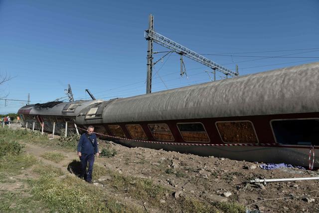 A man walks next to derailed wagons from the derailed train. (AFP Photo)