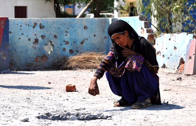 A woman sit on the rooftop of a house damaged by mortar shells fired by the Pakistani army at Jhanghar village, in Nowshera. (Nitin Kanotra/HT Photo)