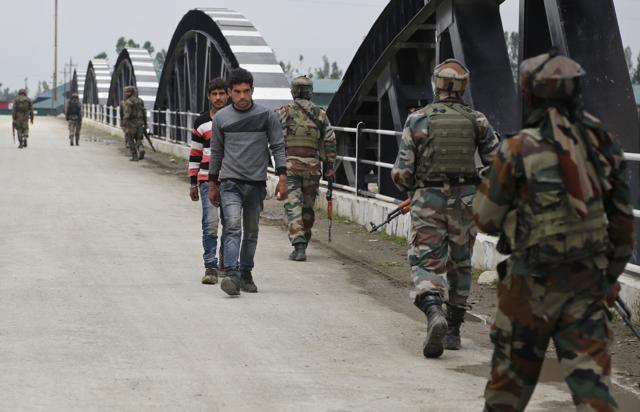 Kashmiri villagers walk past soldiers on a search operation in Shopian. (AP File Photo) Kashmiri villagers walk past soldiers on a search operation in Shopian. (AP File Photo)