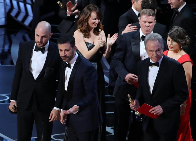 Martha Ruiz (R, in red) and Brian Cullinan (upper R) of PricewaterhouseCoopers confer on stage after the Best Picture was mistakenly awarded to La La Land instead of Moonlight. (REUTERS)