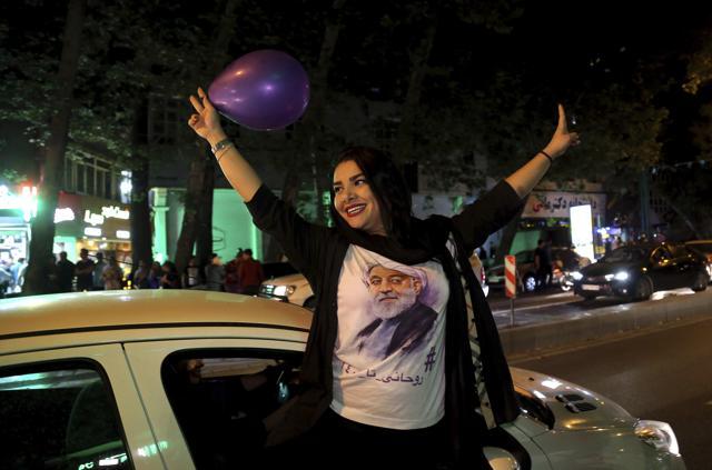 A supporter of Iranian President Hassan Rouhani wears a T-shirt with his image as she attends a street campaign ahead the May 19 presidential election in downtown Tehran, Iran, Wednesday, May 17, 2017. (AP Photo)
