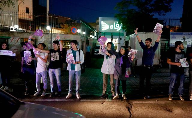 Supporters of Iranian President and candidate elections Hassan Rouhani distribute brochures ahead of the Iranian presidential election in the streets of the capital Tehran on May 17, 2017. (AFP Photo)