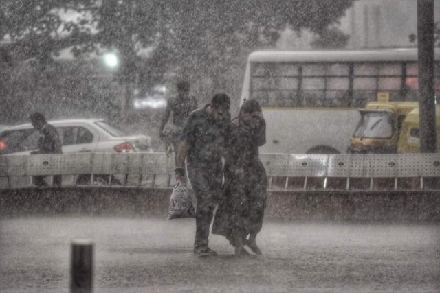 People caught in heavy rainfall near Connaught Place. (Ravi Choudhary/HT Photo)