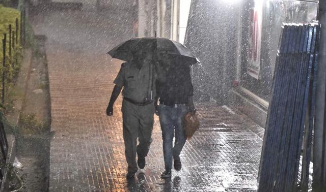 Two people share an umbrella at Connaught Place. (Ravi Choudhary/HT Photo)