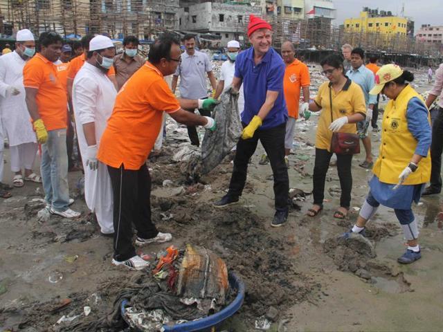 UNEP chief Erik Solheim (in blue) participates in the beach clean-up drive. (HT Photo)