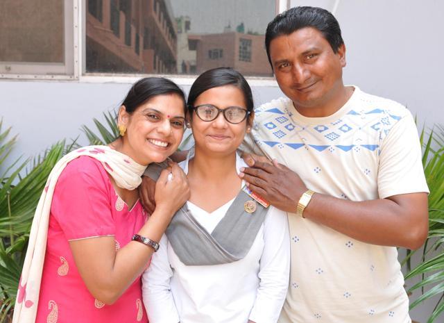 Vaishali, who bagged third position in Jalandhar district, with her father, a labourer, and mother on Monday. (Pardeep Pandit/HT Photo) Vaishali, who bagged third position in Jalandhar district, with her father, a labourer, and mother on Monday. (Pardeep Pandit/HT Photo)