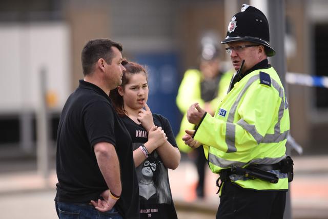 A police officer (R) talks with a man and a girl wearing a T-shirt of US singer Ariana Grande branded for the concert at the Manchester Arena in Manchester. (AFP Photo) A police officer (R) talks with a man and a girl wearing a T-shirt of US singer Ariana Grande branded for the concert at the Manchester Arena in Manchester. (AFP Photo)