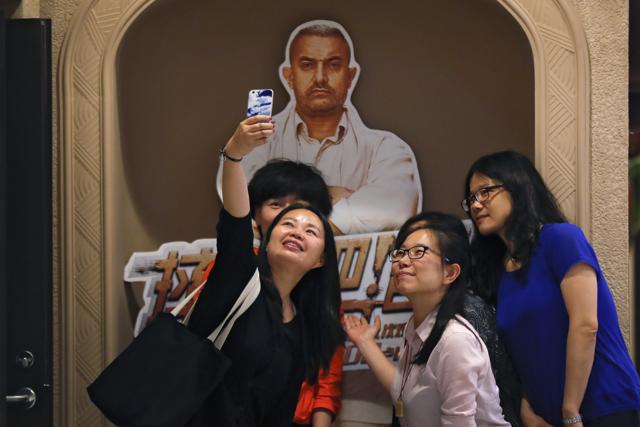 Chinese women take a selfie with a poster of Indian Bollywood blockbuster film Dangal on display at a cinema in Beijing. (AP) Chinese women take a selfie with a poster of Indian Bollywood blockbuster film Dangal on display at a cinema in Beijing. (AP)
