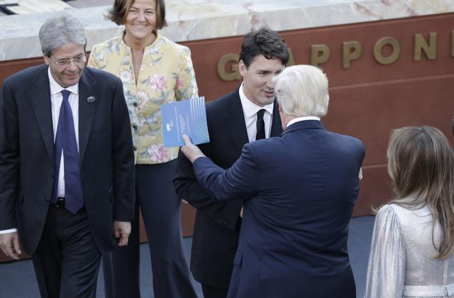 US President Donald Trump talks with Canadian PM Justin Trudeau, while Italian PM Paolo Gentiloni, left, and his wife Emanuela Mauro look on. (AP) US President Donald Trump talks with Canadian PM Justin Trudeau, while Italian PM Paolo Gentiloni, left, and his wife Emanuela Mauro look on. (AP)