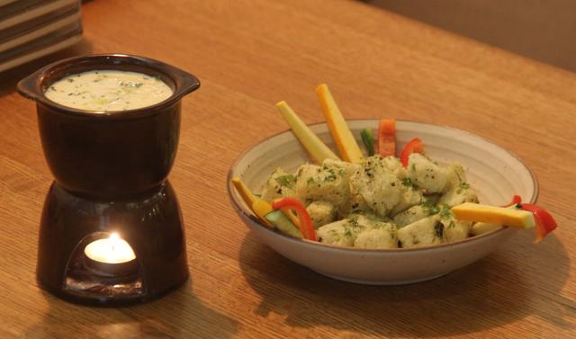 A small pot of classic cheese fondue comes with light, buttery brioche croutons and snappy pepper and zucchini sticks. (Bhushan Koyande / HT Photo)
