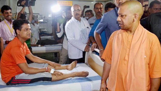 UP chief minister Yogi Adityanath talks to patients during his visit to Kabir Chaura Hospital in Varanasi on Saturday. (PTI)