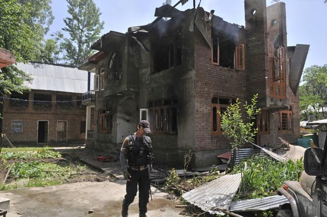 An Indian army soldier stands next to a burning house where militants were killed during a gunfight in the Tral area south of Srinagar on May 27. (Waseem Andrabi / HT Photo) An Indian army soldier stands next to a burning house where militants were killed during a gunfight in the Tral area south of Srinagar on May 27. (Waseem Andrabi / HT Photo)