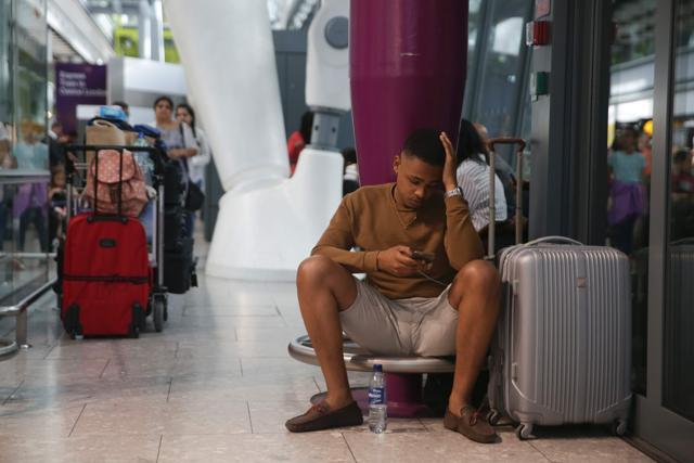 Travellers wait at Heathrow Airport Terminal 5 after British Airways flights where cancelled at Heathrow Airport in west London on Saturday. (AFP)