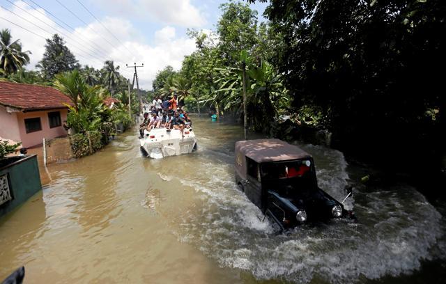 People travel on top of an armoured personnel carrier on a flooded road in Kalutara. (Reuters Photo) People travel on top of an armoured personnel carrier on a flooded road in Kalutara. (Reuters Photo)