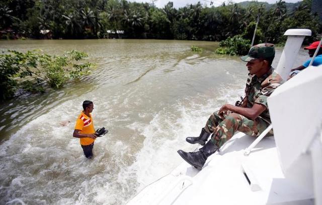 An army officer sits on top of a moving armoured personnel carrier on a flooded road during a rescue mission in Bulathsinhala village, in Kalutara. (Reuters Photo) An army officer sits on top of a moving armoured personnel carrier on a flooded road during a rescue mission in Bulathsinhala village, in Kalutara. (Reuters Photo)