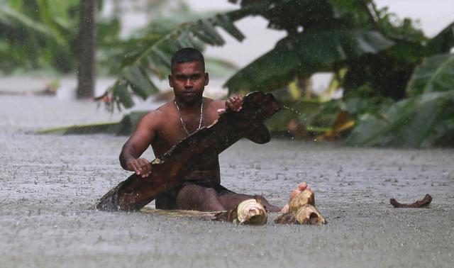 A Sri Lankan man rows a makeshift raft on a flooded road in Wehangalla village. (AP Photo) A Sri Lankan man rows a makeshift raft on a flooded road in Wehangalla village. (AP Photo)