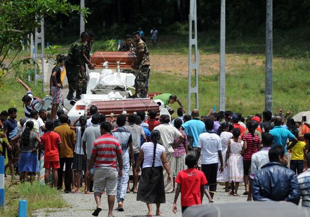 Sri Lankan villagers load coffins of landslide victims onto an army armoured personnel carrier being used in rescue operations during major flooding in Bulathsinhala in Kalutara district on May 27, 2017. (AFP) Sri Lankan villagers load coffins of landslide victims onto an army armoured personnel carrier being used in rescue operations during major flooding in Bulathsinhala in Kalutara district on May 27, 2017. (AFP)