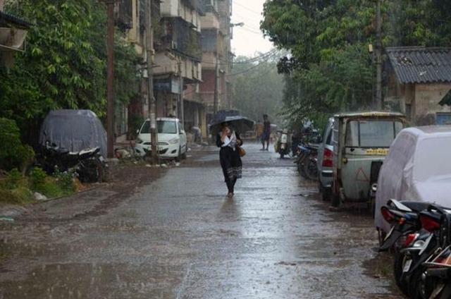 A woman walks through a drizzle in Kalyan. (HT) A woman walks through a drizzle in Kalyan. (HT)
