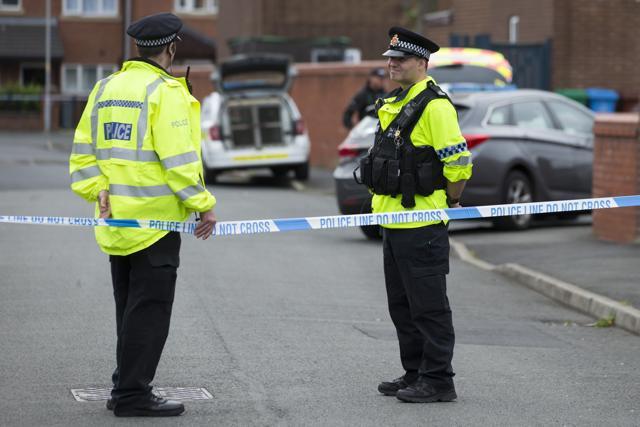 Police officers guard the entrance to a street in the Moss Side area of Manchester on May 28, 2017 during an operation. (AFP photo/ John Super) Police officers guard the entrance to a street in the Moss Side area of Manchester on May 28, 2017 during an operation. (AFP photo/ John Super)