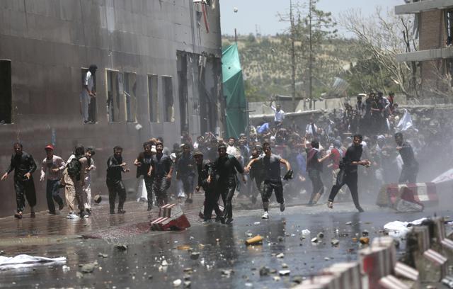Protesters throw stones at security forces in Kabul on Friday. (AP) Protesters throw stones at security forces in Kabul on Friday. (AP)