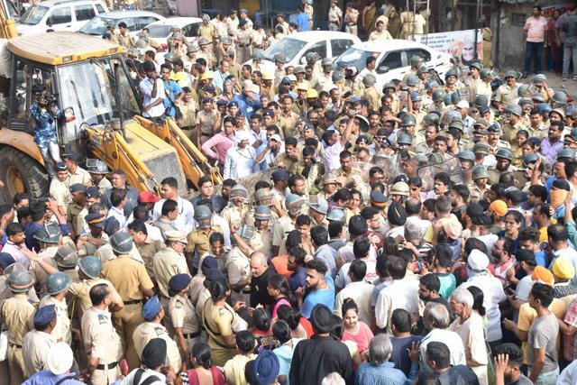 Residents try to stop the demolition. (HT)