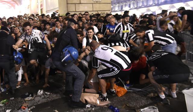 Juventus' fans run away from San Carlo Square following panic created by the explosion of firecrackers as they was watching the match on a giant screen. (REUTERS) Juventus' fans run away from San Carlo Square following panic created by the explosion of firecrackers as they was watching the match on a giant screen. (REUTERS)