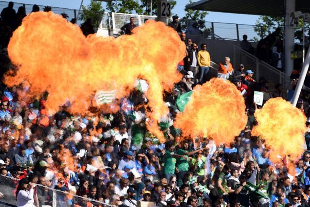 Pakistan cricket fans set off pyrotechnics as they celebrate a boundary. (AFP)