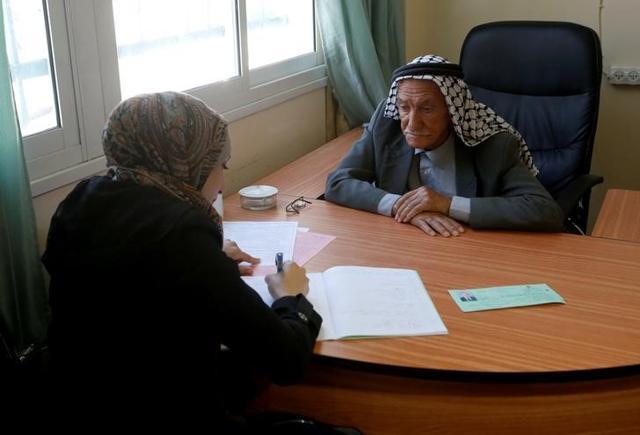 Abdel-Qader Abu Ajameyah dictates his answers to an aid as he takes a high school Arabic Language exam, in the West Bank city of Hebron. (Reuters Photo)