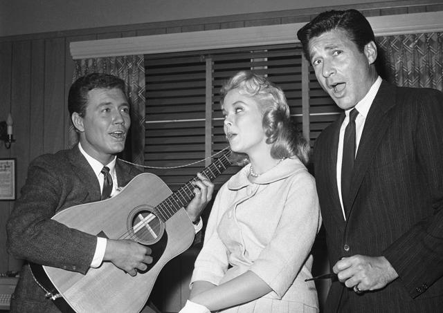 FILE - In this Feb. 15, 1961 file photo, actors Roger Smith, from left, Carolyn Komant and Efrem Zimbalist Jr., tune up for their parts in the TV series "77 Sunset Strip," in Los Angeles. (AP)